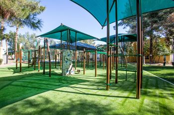 a playground with green umbrellas and swings